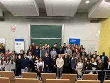 Spotkanie z ambasadorem Rwandy - uczestnicy spotkania na tle ekranu w auli