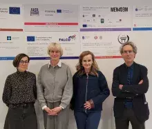 czterech naukowców stojących przed tablicami z informacjami o przyznanych grantach na wydziale nauk społecznych